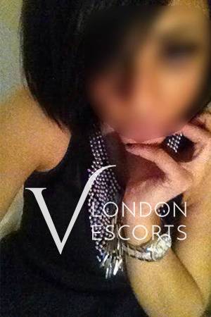 Talia taking a selfie in black dress with shiny jewellery